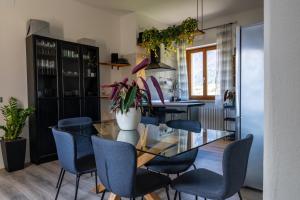 comedor con mesa de cristal y sillas azules en SulGarda Holiday Apartment, en Arco