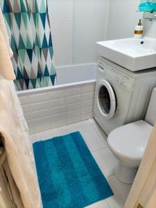 ein Badezimmer mit einer Waschmaschine neben einem WC in der Unterkunft Sunny Home Apartment in Dnipro