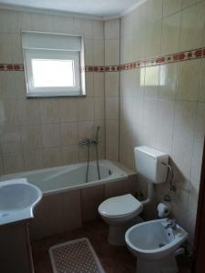 a bathroom with a toilet and a tub and a sink at Apartman Bošnjak Ramsko jezero in Podbor