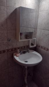 een badkamer met een witte wastafel en een spiegel bij Monoambiente interno en Trelew in Trelew