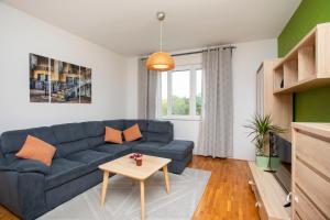 a living room with a blue couch and a table at Downtown Labin in Labin