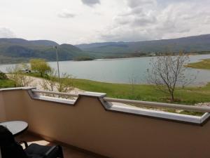 uma vista para um lago a partir da varanda de uma casa em Apartman Bošnjak Ramsko jezero em Podbor