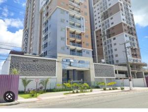 um edifício numa rua da cidade com edifícios altos em Apartamento á 300 metros da praia de Itaparica e efrente o shoping bullevard em Vila Velha