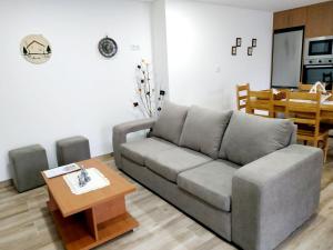 A Casa dos Avós - Alojamento Local في سرتيا: غرفة معيشة مع أريكة رمادية وطاولة