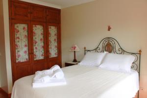 ein Schlafzimmer mit einem Bett mit zwei Handtüchern darauf in der Unterkunft Casa da Chitas in Ponte de Lima + 34 Fotos