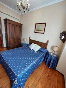 um quarto com uma cama com um edredão azul em Apartamento San Roque Villablino em Villablino
