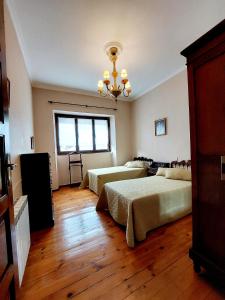 1 dormitorio con 3 camas y lámpara de araña en Apartamento San Roque Villablino en Villablino
