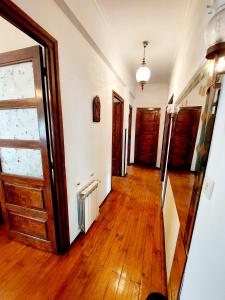 um corredor vazio com pisos de madeira e uma porta em Apartamento San Roque Villablino em Villablino