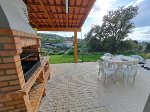 eine Terrasse mit einem Tisch und Stühlen auf einer Terrasse in der Unterkunft A Casa dos Avós - Alojamento Local in Sertã