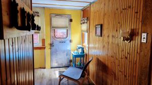 a chair sitting in a room with a door at Train Station Inn in Tatamagouche