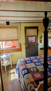 a bedroom with a bed and a table and a door at Train Station Inn in Tatamagouche