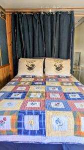 a bed with a quilt and two pillows on it at Train Station Inn in Tatamagouche