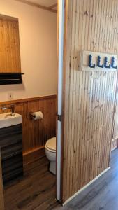 a bathroom with a toilet and a wooden door at Train Station Inn in Tatamagouche