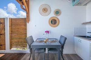 ein Esszimmer mit einem Tisch und Stühlen sowie eine Küche in der Unterkunft Bungalow Ti Banane in Sainte-Luce