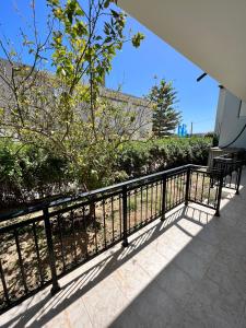 a balcony with two benches and a fence at Porfyra Apartment Portoheli in Porto Heli