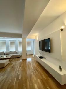 a living room with a flat screen tv on a wall at Golden Apartment in Skopje