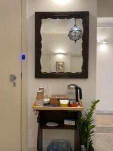 a mirror on a wall next to a table at Casa Obìa in Cagliari +2 photos