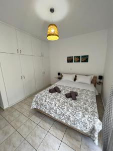 Porfyra Apartment Portoheli في بورتوخيلي: غرفة نوم بسرير كبير مع دواليب بيضاء