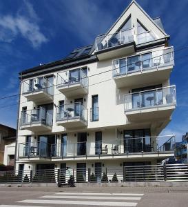 un edificio blanco con balcones en un lateral en Baltic Soul Villa en Międzyzdroje