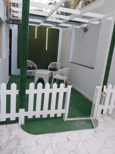 a white picket fence on a patio with a table at استوديو in 6th Of October