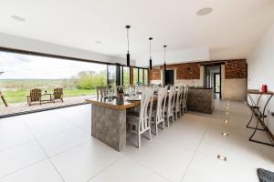 an open kitchen and dining room with a table and chairs at Willow Barn in Haddiscoe