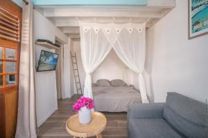 ein Wohnzimmer mit einem Bett und einem Tisch mit Blumen in der Unterkunft Bungalow Ti Banane in Sainte-Luce