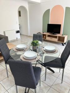 una sala da pranzo con tavolo in vetro e sedie di Porfyra Apartment Portoheli a Porto Heli