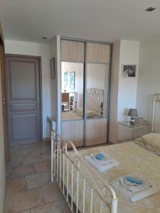 sypialnia z łóżkiem i przesuwnymi szklanymi drzwiami w obiekcie Bandol studio dans villa proximité mer avec piscine w mieście Bandol