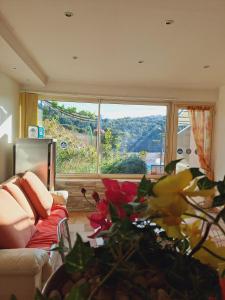 a living room with a couch and a large window at Bandol studio dans villa proximité mer avec piscine in Bandol