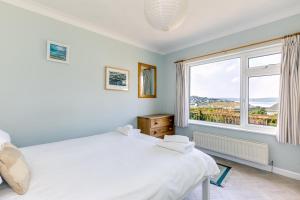 a bedroom with two beds and a large window at Bella Vista in Polzeath
