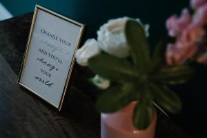 a sign sitting next to a vase with a flower at PLATER PREMIUM APARTMENTS in Warsaw