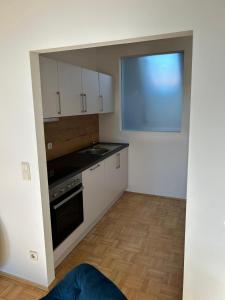 a small kitchen with white cabinets and a window at Gamlitz - RaStra Top 20 in Gamlitz