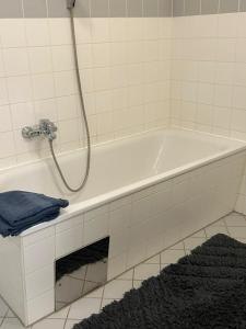 a white bath tub with a shower in a bathroom at Gamlitz - RaStra Top 20 in Gamlitz