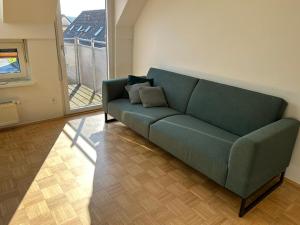 a green couch in a living room with a window at Gamlitz - RaStra Top 20 in Gamlitz