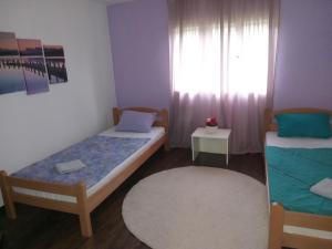 a small room with two beds and a window at Zelena Oaza in Visoko