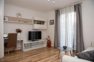 - un salon avec un canapé et une télévision dans l'établissement Apartment Fortuna - peacfull terrace, à Klis