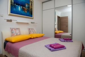 1 Schlafzimmer mit 2 Betten mit gelben und violetten Kissen in der Unterkunft Apartment Fortuna - peacfull terrace in Klis