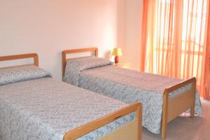 利卡斯戴勒的住宿－Appartamenti e Stanze Onde Blu，带窗户的客房内设有两张单人床。