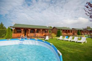 ein Swimmingpool in einem Garten mit einem Haus in der Unterkunft Domki Bartek in Darłowo