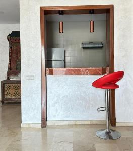 a red stool sitting in front of a counter at Nice Apartment in Marina Agadir in Agadir
