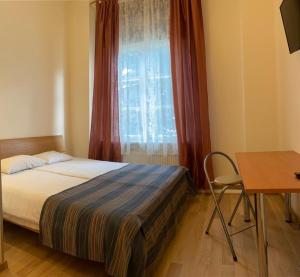 a bedroom with a bed and a window and a desk at Aquamarine Hotel - Lauluväljak in Tallinn