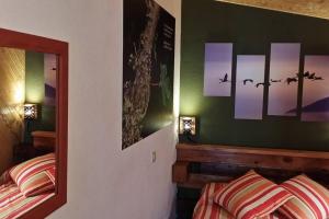 1 dormitorio con 2 camas y pinturas en la pared en Via Fera, con vistas a la naturaleza en Braojos de la Sierra
