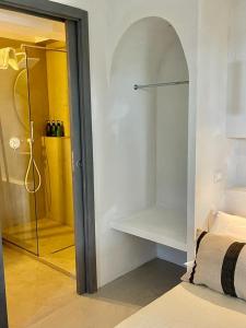 奧斯圖尼的住宿－MAREULIVI，一间卧室设有一张床和一个通往淋浴的玻璃门