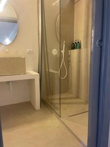 La salle de bains est pourvue d'une douche avec une porte en verre. dans l'établissement MAREULIVI, à Ostuni