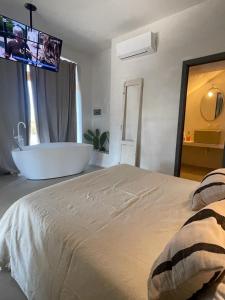 1 dormitorio con 1 cama grande y bañera en MAREULIVI en Ostuni