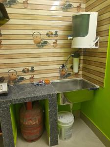 a kitchen with a sink and a tv on the wall at Shanti Kunj Homestay in Agartala