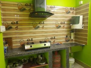 a kitchen with a stove and a sink with pots and pans at Shanti Kunj Homestay in Agartala