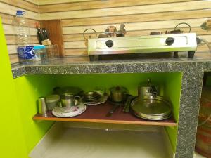 kuchnia z garnkami i patelniami na półce w obiekcie Shanti Kunj Homestay w mieście Agartala