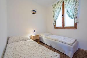 two beds in a room with a window at DOMKI LUNA in Rowy