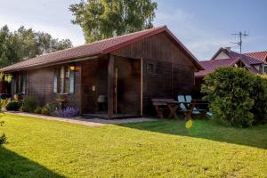 a wooden house with a picnic table in the yard at DOMKI LUNA in Rowy